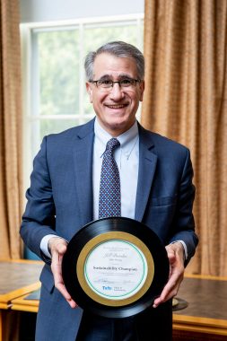 President Anthony Monaco holding a sustainability champion award