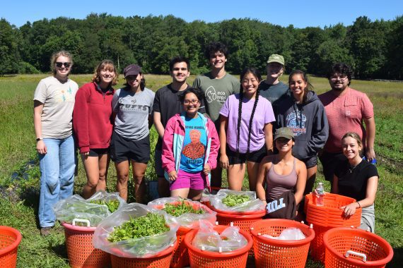 A group of CORE Fellows pose or a picture during volunteer farm work