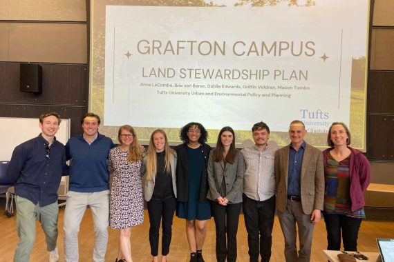 a line of students, faculty, and staff pose after a presentation