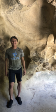 Boy smiling standing in a cave
