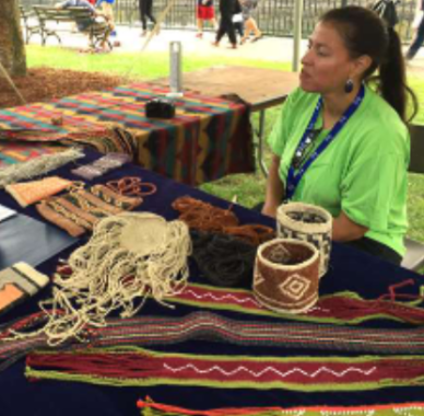 Indigenous artist Elizabeth tabling with her artworks.