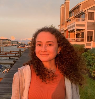 Woman smiling in front of sunset